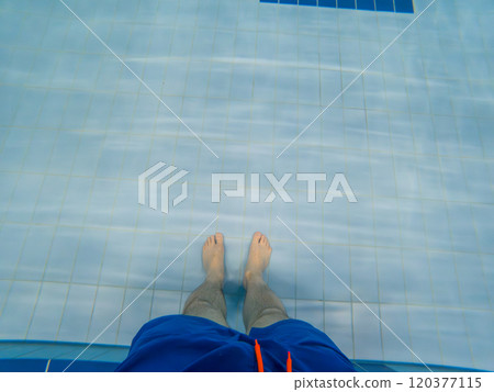 Person Standing in Pool with Blue Swim Trunks 120377115