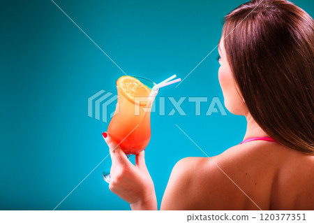 Girl s in swimsuit at poolside with cocktail glass sideview. 120377351