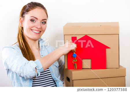 Woman moving in with boxes and paper house key. Woman moving in with boxes and paper house key. 120377388
