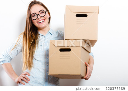 Happy woman moving into house carrying boxes. Happy woman moving into house carrying boxes. 120377389