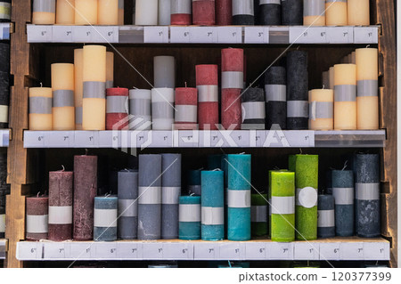 Candles for sale in interior decorating store. Colored variety paraffin candles in cozy candle shop. Assortment of different candles. Candles for sale in interior decorating store. Colored variety paraffin candles in cozy candle shop. Assortment of different candles. 120377399