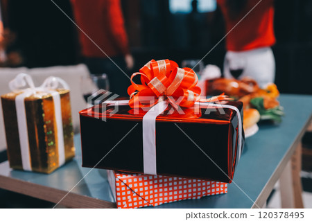 Group of young Asian man and women as friends having fun at a New Year's celebration, holding gift boxes standing by Christmas tree decoration, midnight countdown Party at home with holiday season. Group of young Asian man and women as friends having fun at a New Year's celebration, holding gift boxes standing by Christmas tree decoration, midnight countdown Party at home with holiday season. 120378495