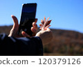 Autumn leaves, woman taking photos with smartphone, image 120379126