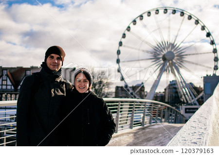 A young couple hugs in front of the Ferris wheel in Gdansk 120379163