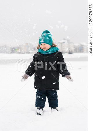 Boy child is standing in the snow, smiling and enjoying winter weather 120379258