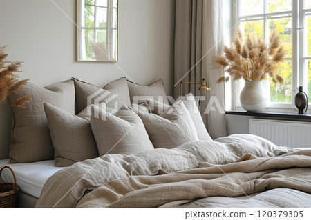 Minimalistic interior of bedroom with a white comforter and pillows on bed near window 120379305