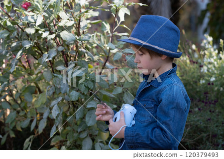 Little boy taking photo in Autumn season. 120379493