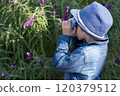 Little boy taking photo in the garden.Autumn season. 120379512