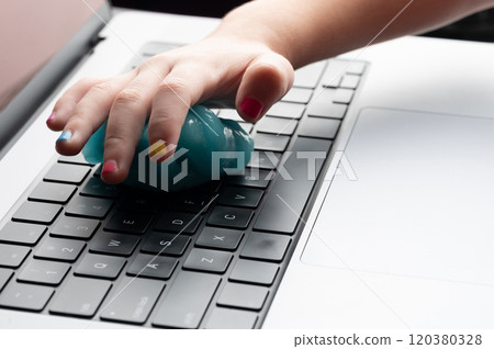 Hand with colorful nails cleaning laptop keyboard 120380328