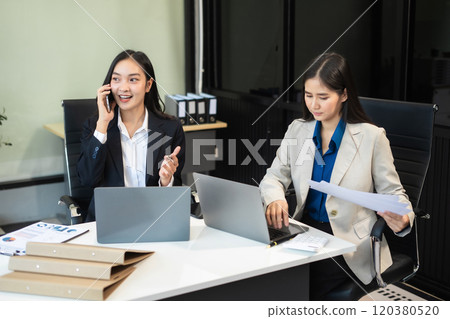 Two busy happy business woman executive leaders team using laptop working on computer. Two busy happy business woman executive leaders team using laptop working on computer. 120380520