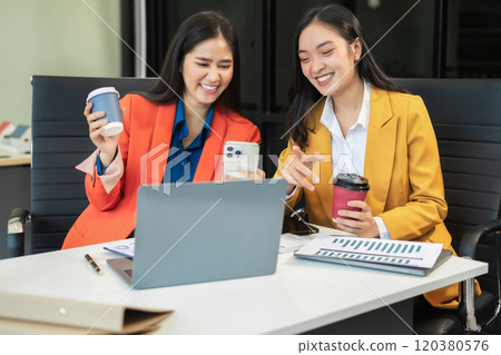 female colleague of half Asian descent holds a cup of coffee and smiles happily. 120380576
