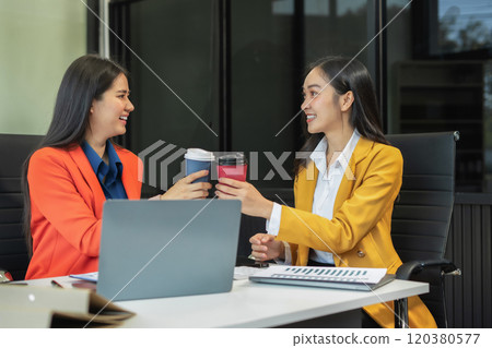 female colleague of half Asian descent holds a cup of coffee and smiles happily. female colleague of half Asian descent holds a cup of coffee and smiles happily. 120380577