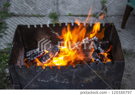 Barbecue grill mangal preparation with roaming fire outside building. Burns a firewood Barbecue grill mangal preparation with roaming fire outside building. Burns a firewood 120380797