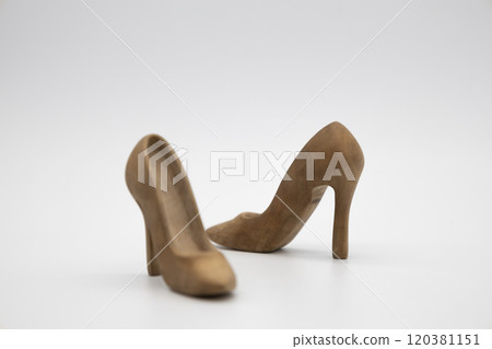 Pair of women's shoes made from wood. A beautiful high-heeled wooden shoes against white background. Handmade shoes for use in female concept 120381151
