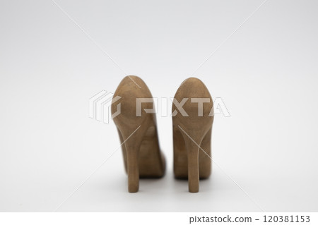 Pair of women's shoes made from wood. A beautiful high-heeled wooden shoes against white background. Handmade shoes for use in female concept 120381153