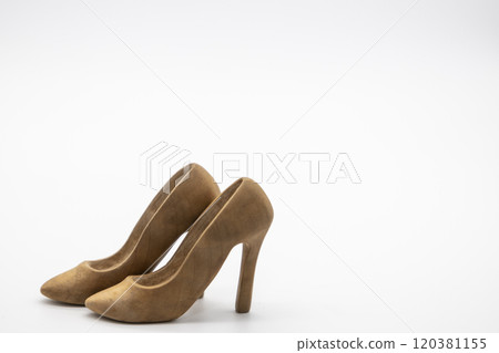 Pair of women's shoes made from wood. A beautiful high-heeled wooden shoes against white background. Handmade shoes for use in female concept Pair of women's shoes made from wood. A beautiful high-heeled wooden shoes against white background. Handmade shoes for use in female concept 120381155