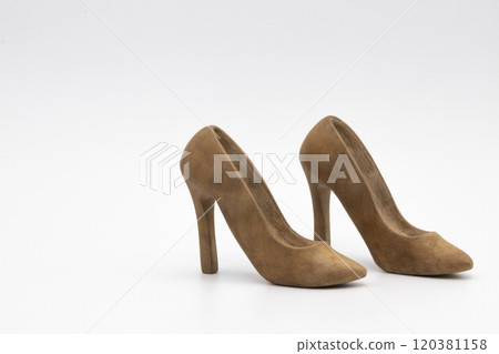 Pair of women's shoes made from wood. A beautiful high-heeled wooden shoes against white background. Handmade shoes for use in female concept 120381158