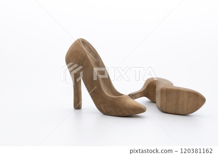 Pair of women's shoes made from wood. A beautiful high-heeled wooden shoes against white background. Handmade shoes for use in female concept 120381162