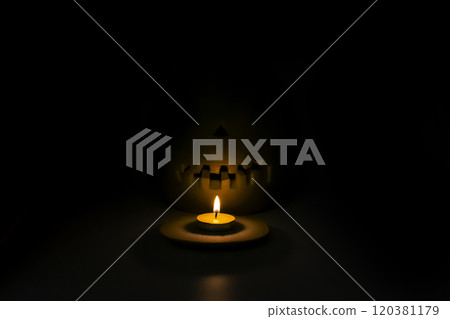 Helloween symbol with scary face behind a candel with fire 120381179