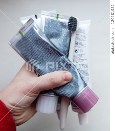 Woman holds many tubes of oral hygiene products in her hand. Using natural toothpaste with safe sweeteners and eco-friendly ingredients 120381922