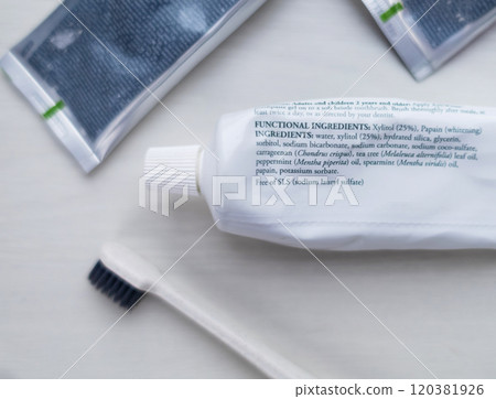 A tube of natural toothpaste with safe ingredients is lying on the table. List of natural components and ingredients. Use of ecological oral care products A tube of natural toothpaste with safe ingredients is lying on the table. List of natural components and ingredients. Use of ecological oral care products 120381926