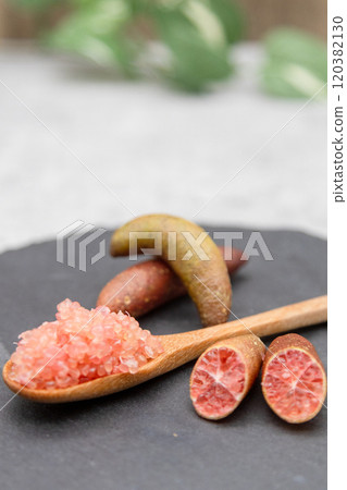 Finger lime on a black plate and spoon Finger lime flesh and cross section 120382130