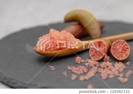Finger lime on a black plate and spoon Finger lime flesh and cross section 120382132
