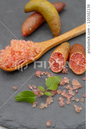 Finger lime on a black plate and spoon Finger lime flesh and cross section Finger lime on a black plate and spoon Finger lime flesh and cross section 120382136