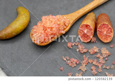 Finger lime on a black plate and spoon Finger lime flesh and cross section Finger lime on a black plate and spoon Finger lime flesh and cross section 120382139