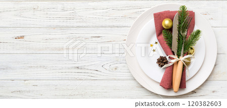 Christmas table place setting with christmas decor and plates, kine, fork and spoon. Christmas holiday background. Top view with copy space 120382603
