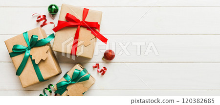 wrapped christmas or other holiday handmade present in paper with colored ribbon. Present box, decoration of gift on colourfull table, top view with copy space wrapped christmas or other holiday handmade present in paper with colored ribbon. Present box, decoration of gift on colourfull table, top view with copy space 120382685