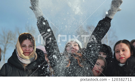Happy schoolgirls enjoy tossing snow in the air, having a blast on a sunny winter day outside Happy schoolgirls enjoy tossing snow in the air, having a blast on a sunny winter day outside 120382711