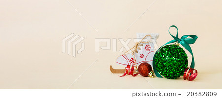 Christmas ball with skates on colored background. decoration bauble with ribbon bow with copy space 120382809