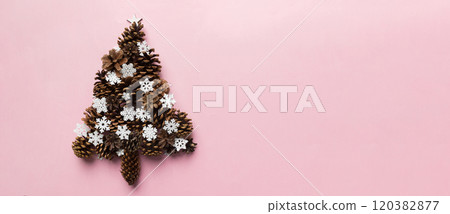 Christmas tree made from natural cones on colored background, view from above. New Year minimal concept with copy space 120382877