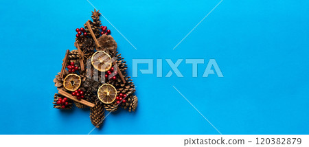 Christmas tree made from natural cones on colored background, view from above. New Year minimal concept with copy space Christmas tree made from natural cones on colored background, view from above. New Year minimal concept with copy space 120382879