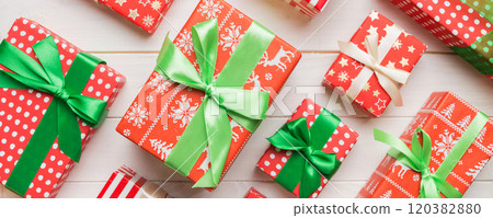 A lot of Christmas gift boxes in colored paper decorated on table, Top view close up. Many present New Year gift A lot of Christmas gift boxes in colored paper decorated on table, Top view close up. Many present New Year gift 120382880