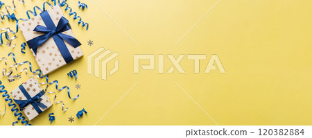 Holiday flat lay with gift boxes wrapped in colorful paper and tied decorated with confetti on colored background. Christmas, Birthday, Valentine and sale concept, top view Holiday flat lay with gift boxes wrapped in colorful paper and tied decorated with confetti on colored background. Christmas, Birthday, Valentine and sale concept, top view 120382884