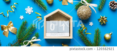Christmas calendar 1 january. Christmas gift, fir branches, pine cones. Flat lay, top view. New Year decorations on a colored background 120382921