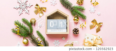 Christmas calendar 1 january. Christmas gift, fir branches, pine cones. Flat lay, top view. New Year decorations on a colored background 120382923