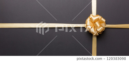 Top view of gold ribbon rolled and yellow bow isolated on colored background. Flat lay with copy space 120383098