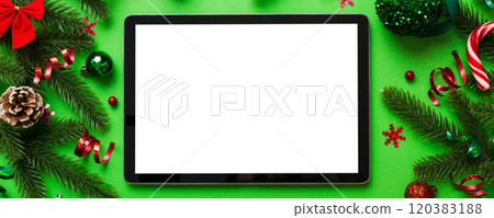 Top view of empty tablet on Christmas background made of new year decorand festive decorations. New year holiday concept. Mockup Top view of empty tablet on Christmas background made of new year decorand festive decorations. New year holiday concept. Mockup 120383188