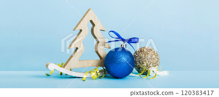 Christmas ball with decorative wooden tree on colored background. decoration bauble with ribbon bow with copy space 120383417