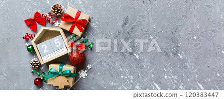 Christmas calendar 25 december. Christmas gift, fir branches, pine cones. Flat lay, top view. New Year decorations on a colored background 120383447