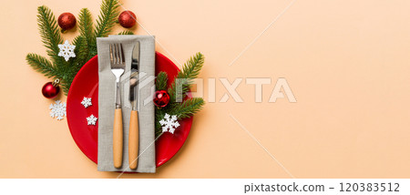 Christmas table place setting with christmas decor and plates, kine, fork and spoon. Christmas holiday background. Top view with copy space Christmas table place setting with christmas decor and plates, kine, fork and spoon. Christmas holiday background. Top view with copy space 120383512