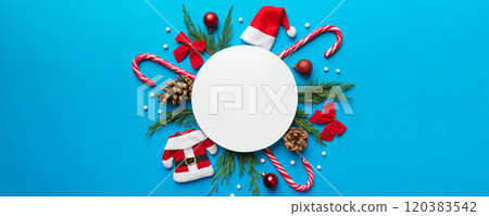Flat lay Christmas composition. Round Paper blank, pine tree branches, christmas decorations on Colored background. Top view, copy space for text 120383542