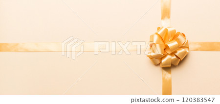 Top view of gold ribbon rolled and yellow bow isolated on colored background. Flat lay with copy space 120383547