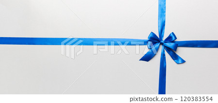 Top view of blue ribbon rolled and blue bow isolated on colored background. Flat lay with copy space Top view of blue ribbon rolled and blue bow isolated on colored background. Flat lay with copy space 120383554