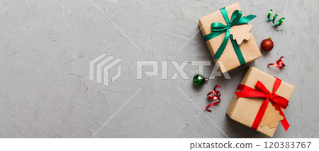 wrapped christmas or other holiday handmade present in paper with colored ribbon. Present box, decoration of gift on colourfull table, top view with copy space 120383767