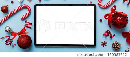 Top view of empty tablet on Christmas background made of new year decorand festive decorations. New year holiday concept. Mockup Top view of empty tablet on Christmas background made of new year decorand festive decorations. New year holiday concept. Mockup 120383812