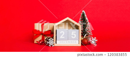25 december. Christmas composition on colored background with a wooden calendar, with a gift box, toys, bauble copy space 25 december. Christmas composition on colored background with a wooden calendar, with a gift box, toys, bauble copy space 120383855